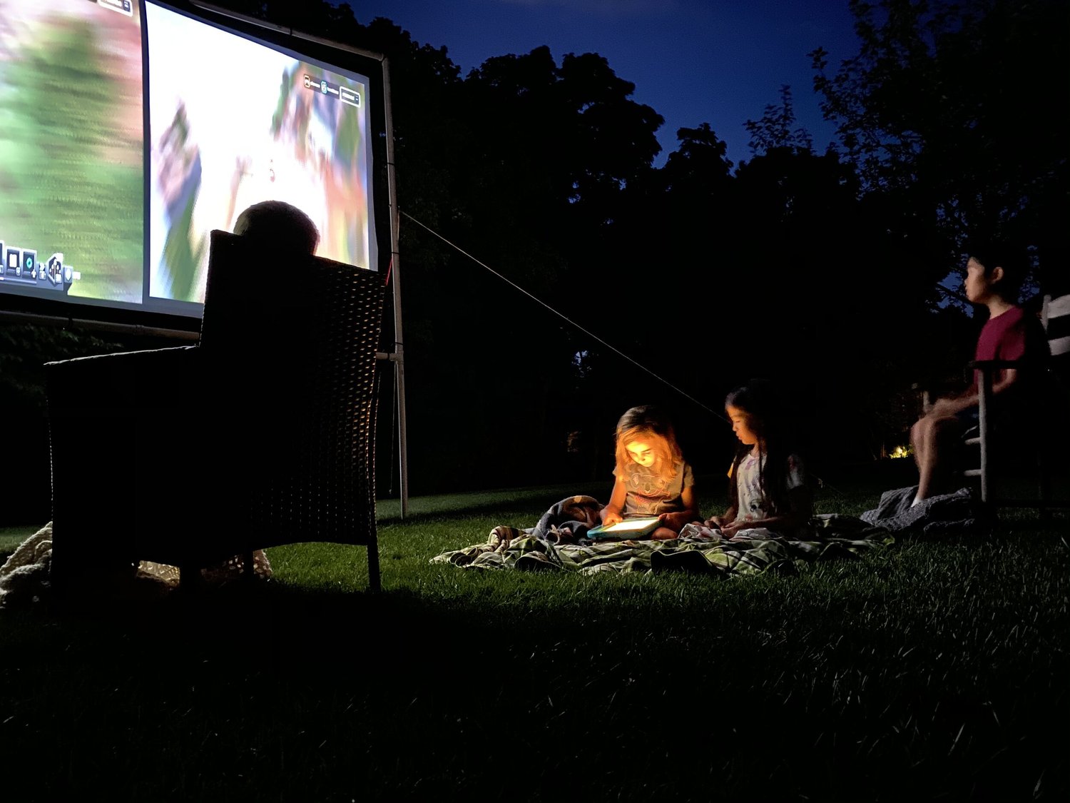 Kids watching projector in backyard